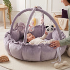 Baby reaching for a hanging panda toy in the lavender play gym nest