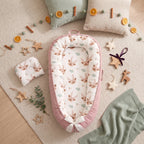 Top view of the reindeer print baby nest with a white bow at the foot