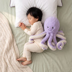 Toddler resting with a purple octopus soft toy with cream ribbed tentacles
