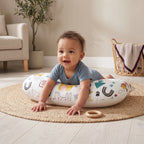 Smiling baby pushing up on their arms during tummy time on the U-shaped pillow