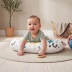 Baby doing tummy time on the Jungle print U-shaped pillow, with a parent close by