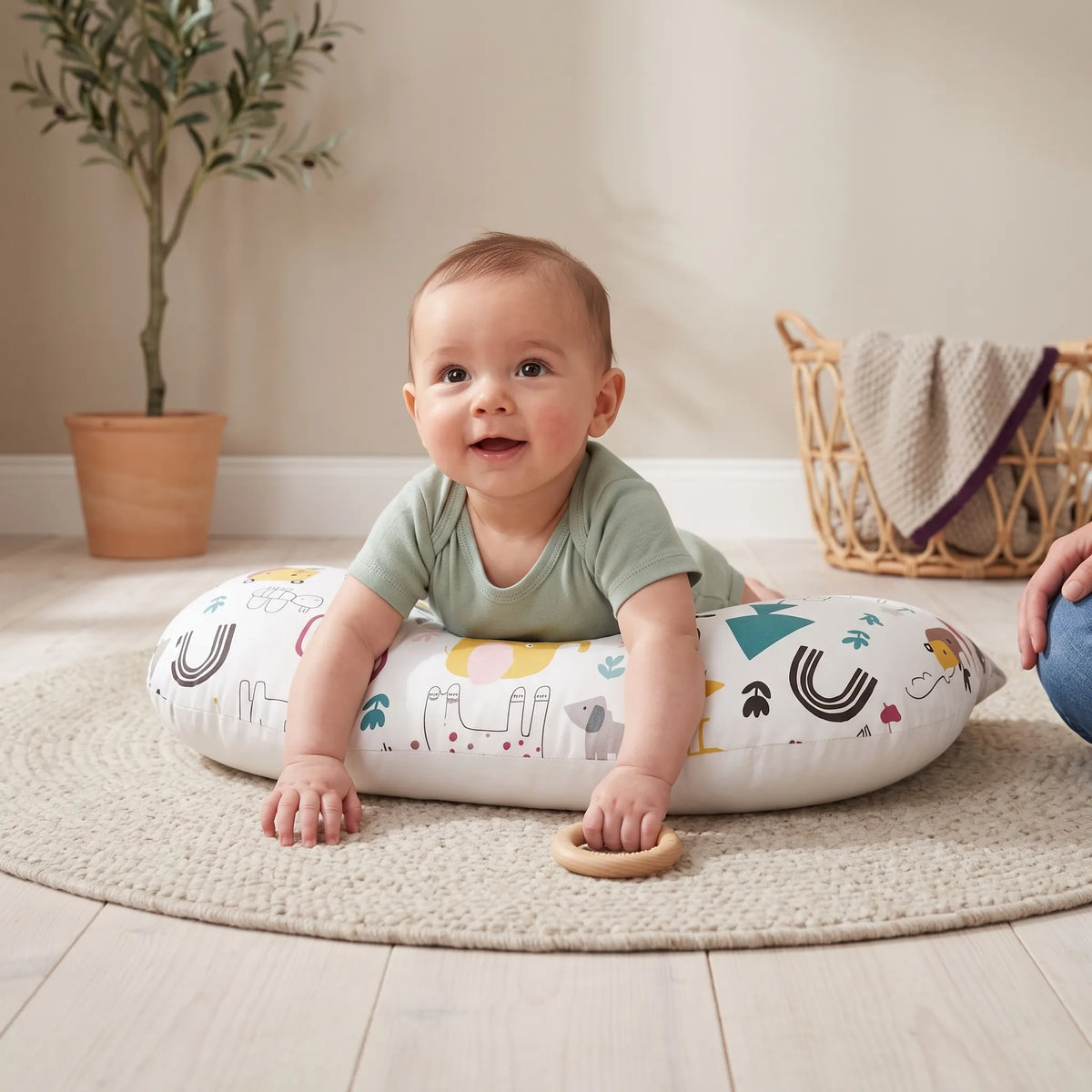 Baby doing tummy time on the Jungle print U-shaped pillow, with a parent close by