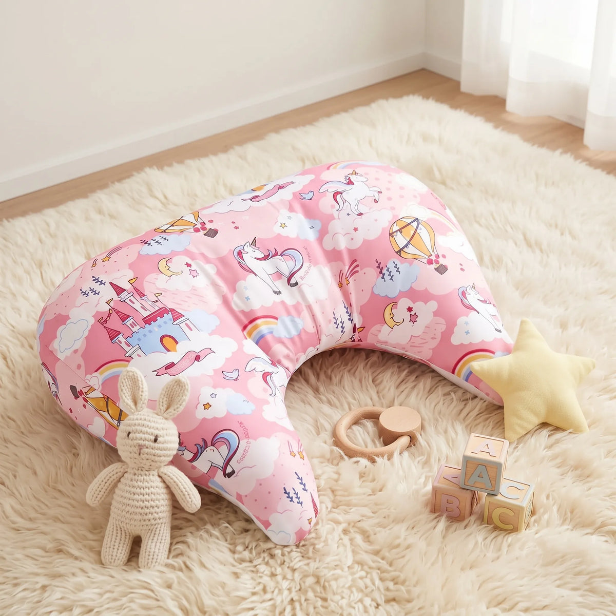 Pink Aurora Castle tummy time pillow on a soft rug with toys