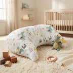 U-shaped tummy time pillow beside a cot in a bright nursery