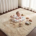 Baby enjoying tummy time on the U-shaped pillow, surrounded by toys