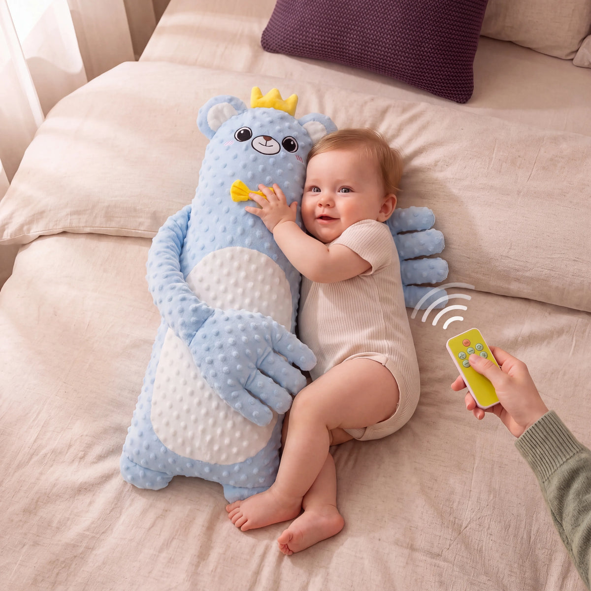 Smiling baby cuddling the Sandy Blue Bear patting pillow while a parent adjusts the speed with the wireless remote